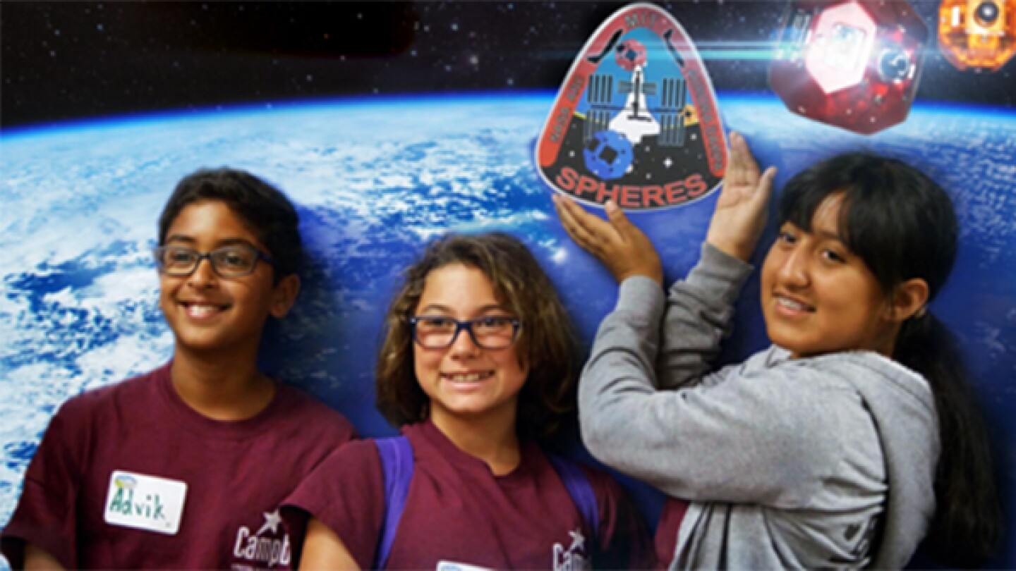 Three young people smiling as they pose side by side, with a background image of Earth from space.