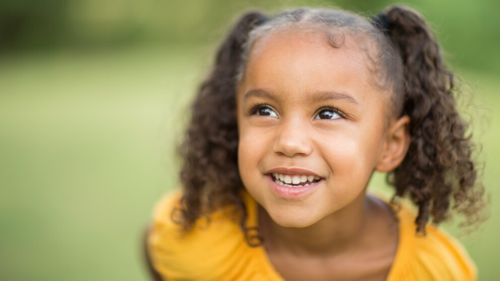 Beautiful little brown girl laughing and smiling.