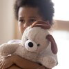 A sad-looking little boy hugs a stuffed dog tightly. iStock
