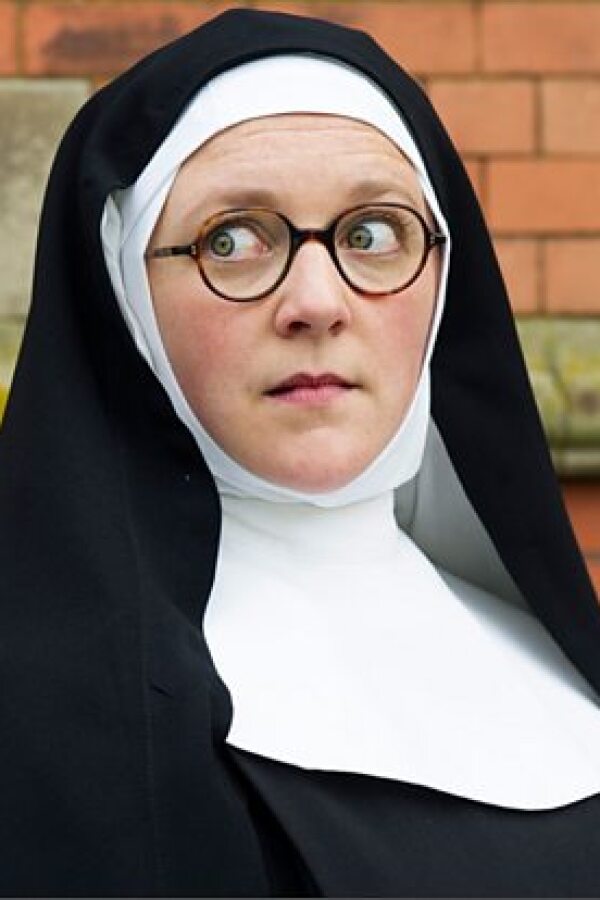 Sister Boniface in front of a brick wall.