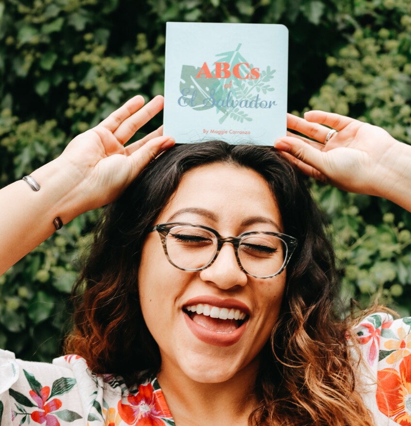 Author Maggie Carranza poses with her book "ABCs of El Salvador"