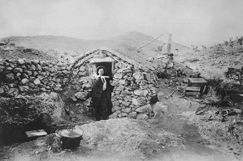 Photograph of an unknown miner at his stone dugout near Randsburg, CA, ca. 1900 -1920. | Courtesy of USC Libraries and California Historical Society.