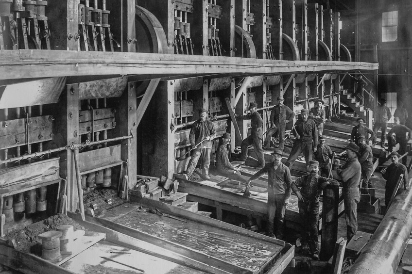 Randsburg’s Yellow Aster 100-stamp mill worked 24/7 crushing ore which is shown here spilling down onto mercury-coated plates in the lower left corner of the image. | Charles C. Pierce, ca. 1900. Image courtesy of Huntington Library Collection.