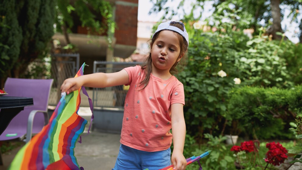 Little girl whistling while playing around with her kite