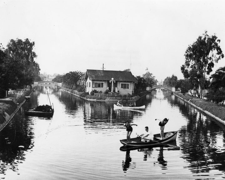 Two women dive into canals that are now paved roadways. Behind them is tiny United States Island. Courtesy of the Security Pacific National Bank Collection - Los Angeles Public Library.