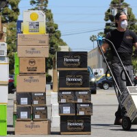 Employee with a hand truck moves shipments of alcohol into warehouse | Karen Foshay